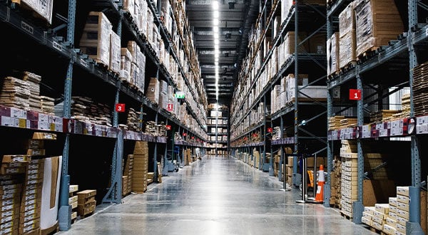 Looking down a long aisle of product in a warehouse