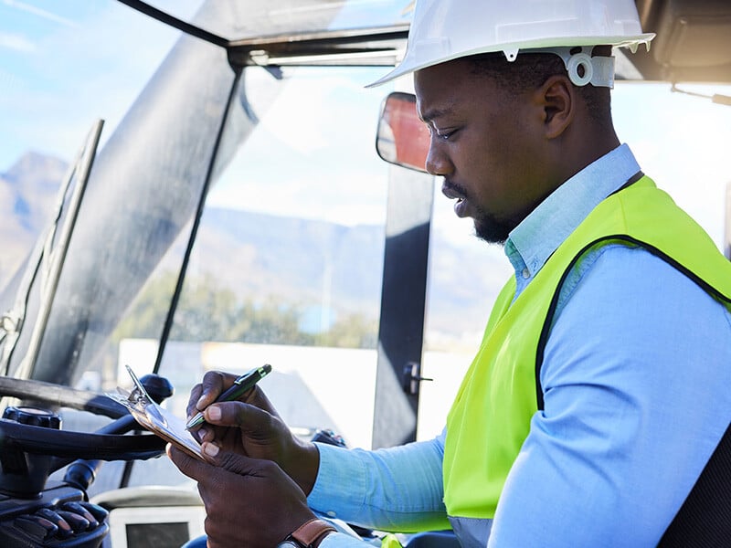 Forklift driver marking a checklist