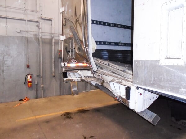 Open rear semi-truck door in need of trailer body work