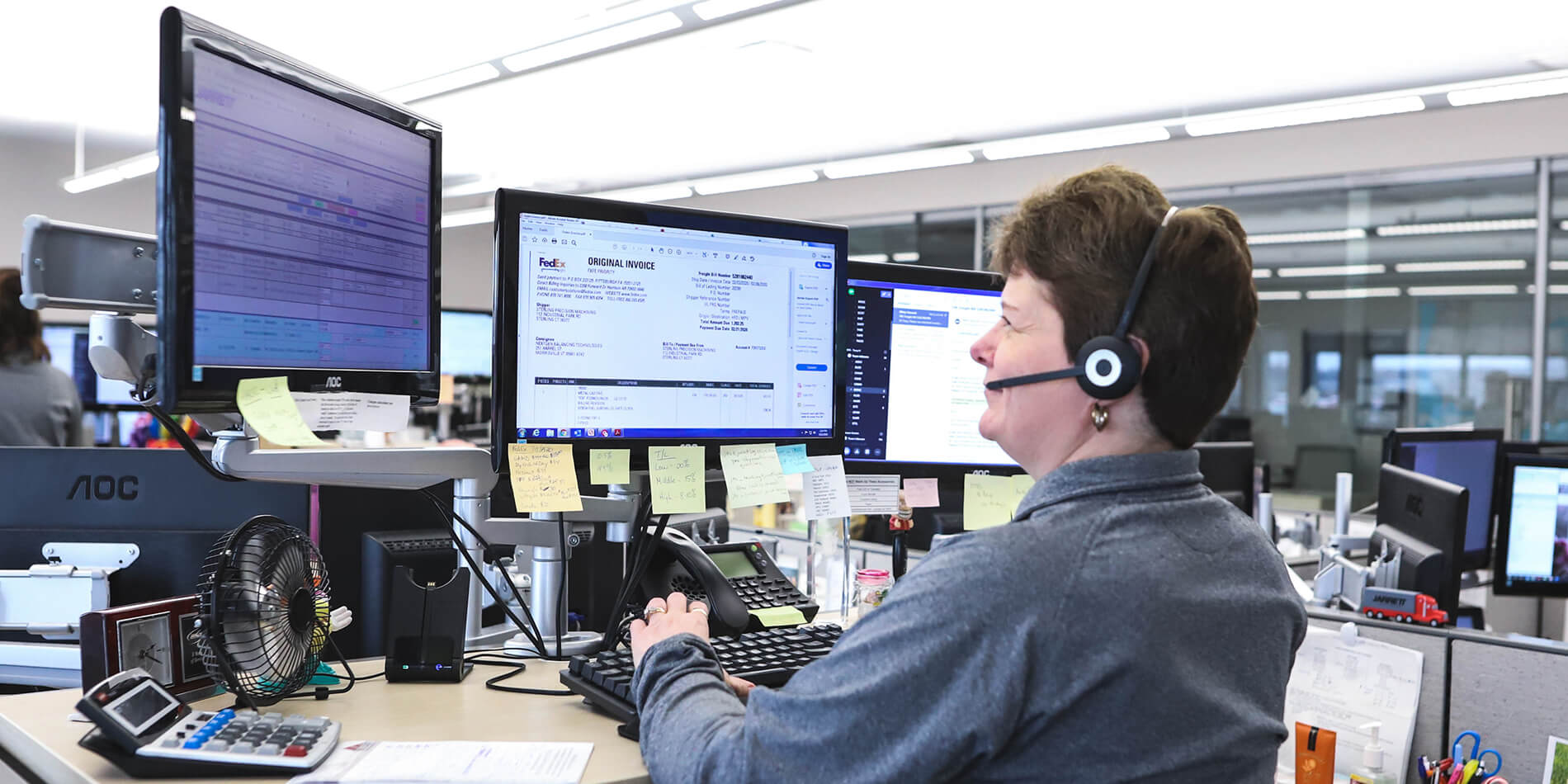 Jarrett Routing Center employee viewing computer screens while talking on a headset.
