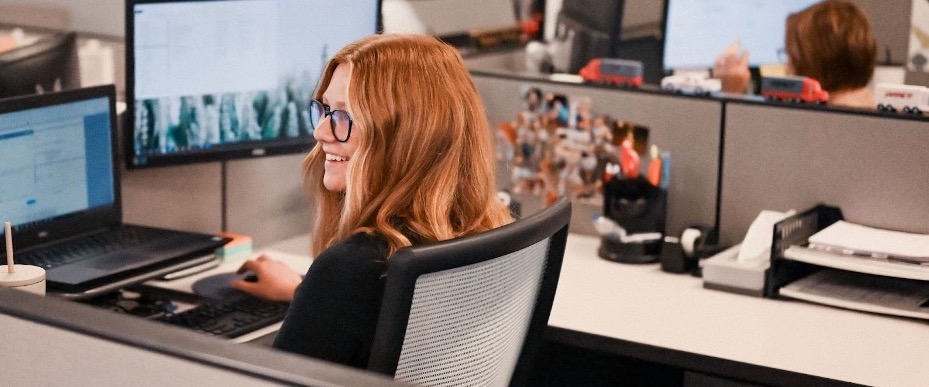 Jarrett Employee smiles while working at their office desk